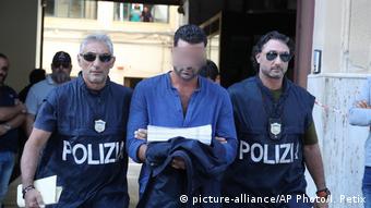 Итальянские полицейские ведут предполагаемого члена мафиозной группировки