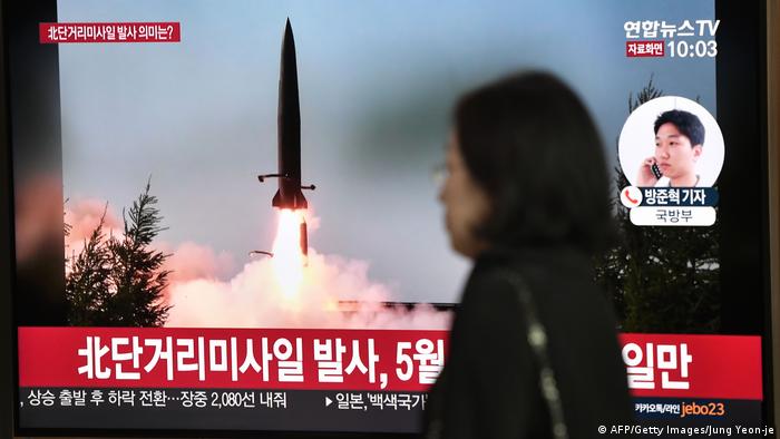 Mulher diante de tela de televisÃ£o mostrando disparo de um foguete na Coreia do Norte
