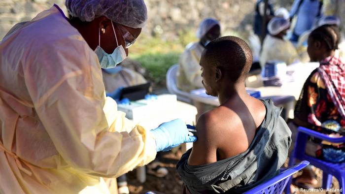 A health worker vaccinates a man in DRC (Reuters/O. Acland)
