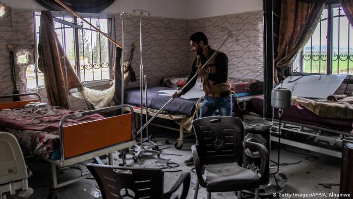 A man clears rubble at a damaged hospital ward in Saraqib. Amer Alhamwe / AFP
