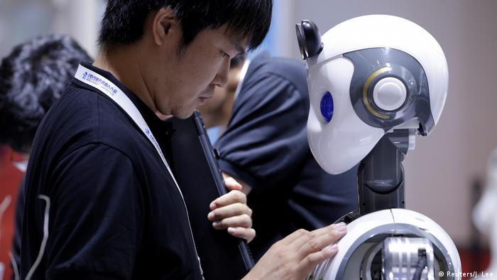 Человек и робот на Всемирной конференции роботов в Пекине
