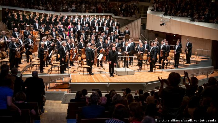 Orchestra members, choristers and conductor onstage in the Berlin Philharmonie (picture-alliance/dpa/B. von Jutrczenka)