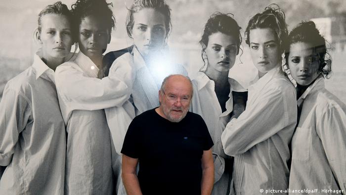 Петер Линдберг на фоне своей работы, представленной на выставке в Мюнхене в 2017 году