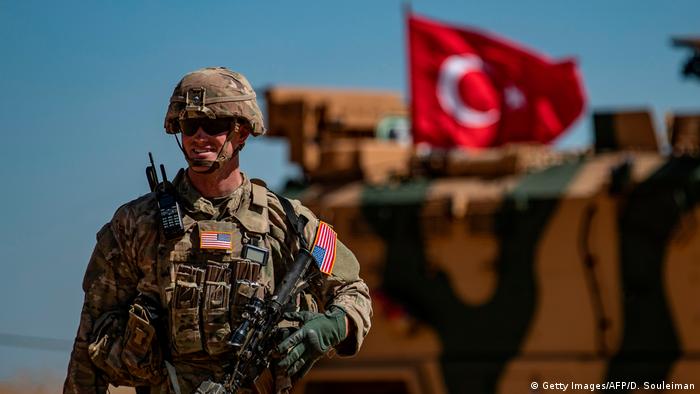 Soldado americano e um tanque militar turco em patrulha no norte da Síria, perto da fronteira com a Turquia