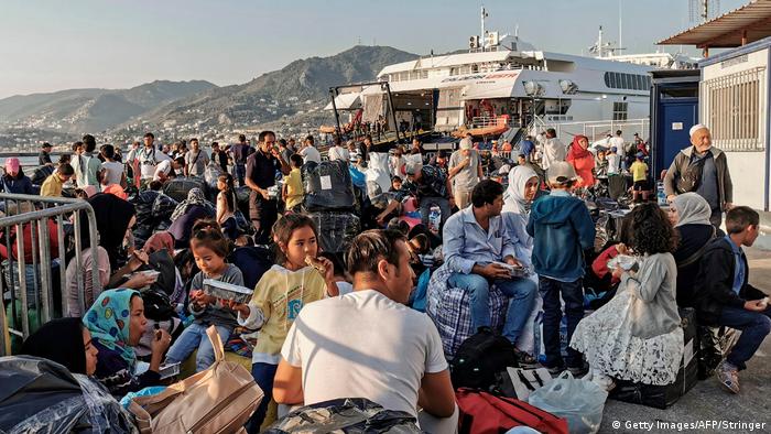 Migrants and refugees wait to board a ship at the port of Mytilene (Getty Images/AFP/Stringer)
