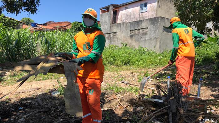 Na luta contra a dengue, funcionários limpam terreno baldio em Aracaju, Sergipe