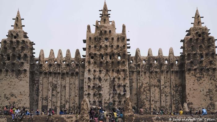 People sit in front of the Great Mosque of Djenne, Mali (Getty Images/AFP/M. Cattani)