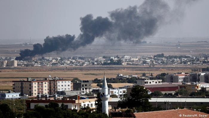 Дым, поднимающийся над сирийским городом Рас-эль-Айн после воздушного удара Турции