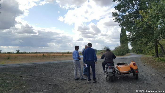 Немцы разговаривают с местным жителем, приехавшим на мотоцикле