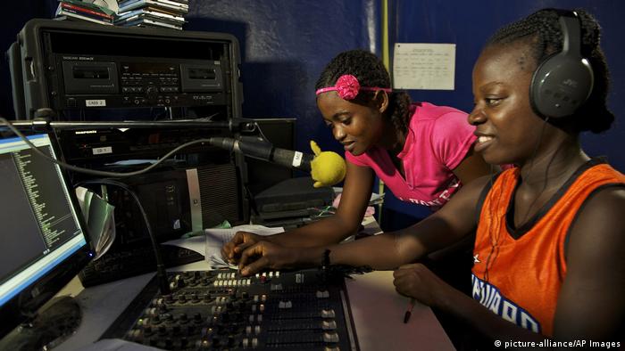 Two young women broadcast from a radio panel in Liberia 