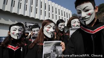 Maskierte Hongkonger Studenten singen bei ihrem Abschluss (picture-alliance/AP/K. Cheung)