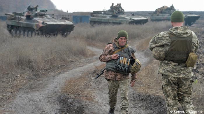 Ukrainian troops in a field with APCs (Reuters/O. Klymenko)