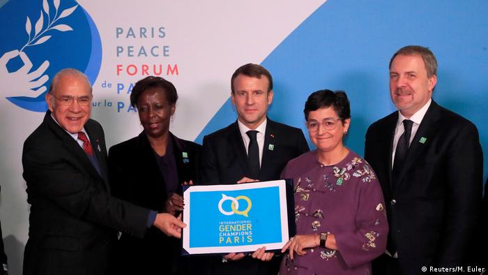 French President Emmanuel Macron, OECD Secretary-General Angel Gurria and other U.N. officers hold a placard promoting gender equality at the Paris Peace Forum 