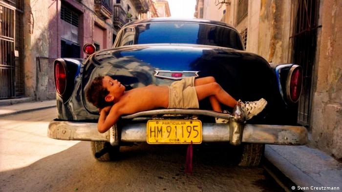 Снимка и история едновременно: 7-годишният Ернесто от Хавана се изтяга върху бронята на един американски олдтаймер в старата част на кубинската столица. Снимка, която показва колко млад е старият град.