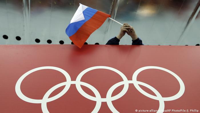 Russian flag is held above the Olympic Rings