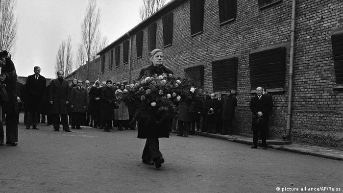 El excanciller alemán Helmut Schmidt lleva una corona de flores en el ex campo de exterminio alemán nazi de Auschwitz.