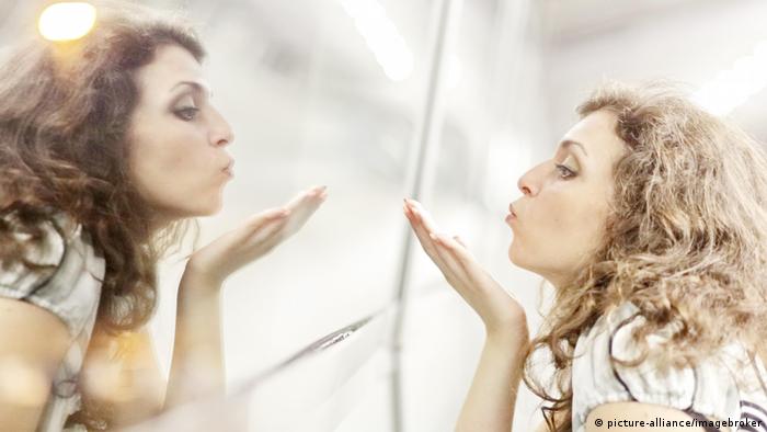 Mujer mirándose en un espejo.
