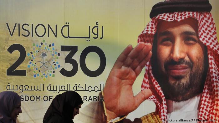 Vision 2030 in letters on the wall of a building with the face of the Crown Prince Mohammed bin Salman (picture-alliance/AP Photo/A. Nabil)