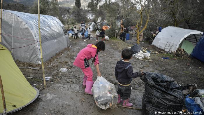 Children help clear up rubbish at a migrant camp after a heavy bout of rain on the island of Chios in December (Getty Images/AFP/L. Gouliamaki)