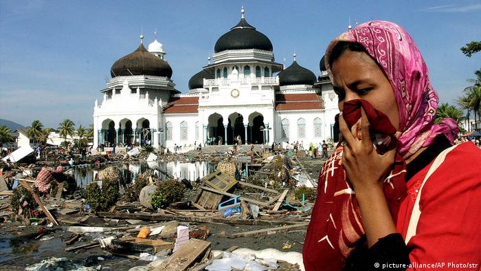 A woman walks near a mosque amid rubbish from the Indian Ocean tsunami in December 2004 (picture-alliance/AP Photo/str)