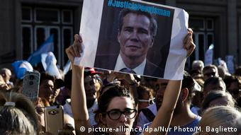 Foto de mujer que porta una foto de Nisman durante marcha por aniversario de su muerte.