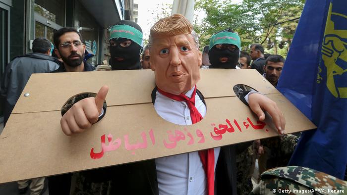 An Iranian protester dressed as US president Donald Trump in a pillory