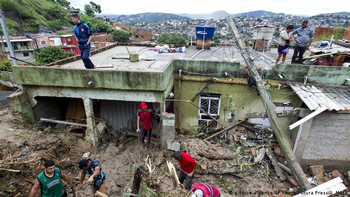 Several men clear debris following a landslide (picture-alliance/AP Photo/Futura Press/A. Mota)