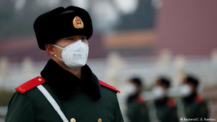 Chinese officer in Beijing wears mask (Reuters/C. G. Rawlins)