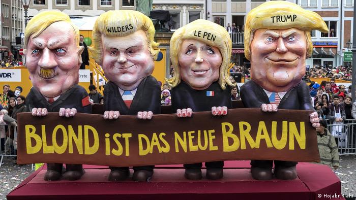 Four figures ( Trump, Le Pen, Wilders und Adolf Hitler.) with blond hair and a large banner that reads blond is thre new brown Schloss Oberhausen Ludwiggalerie Ausstellung Jacques Tilly (Hojabr Riahi)