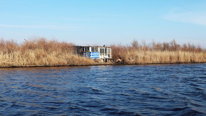 A hut on the Evros river with a Greek flag
