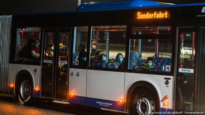 Evacuees arrive in Germersheim on a special chartered bus wearing facemasks