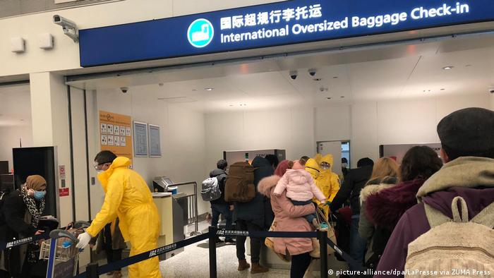 Passengers line up at check in at Wuhan airport