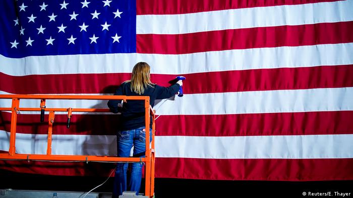 A woman steams the wrinkles from a flag