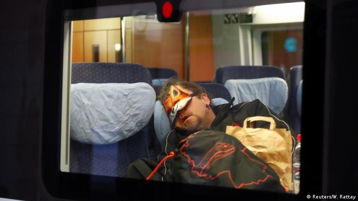 Man sleeps with face mask in ICE train