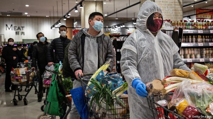 Residents wear protective masks as they line up in the supermarket on February 12, 2020 in Wuhan, Hubei province, China