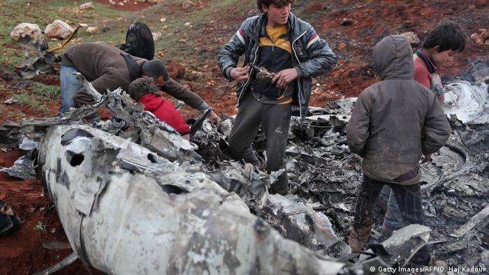 Syrians inspect the wreckage of a military helicopter belonging to government forces after it was shot down over Aleppo province on February 14, 2020