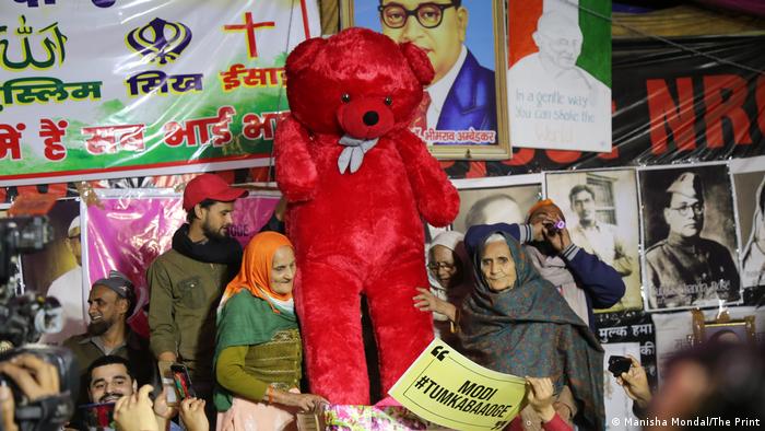 Indian protesters with a giant red teddy bear 