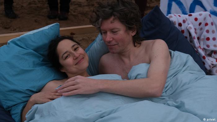 Protesters hold each other in bed