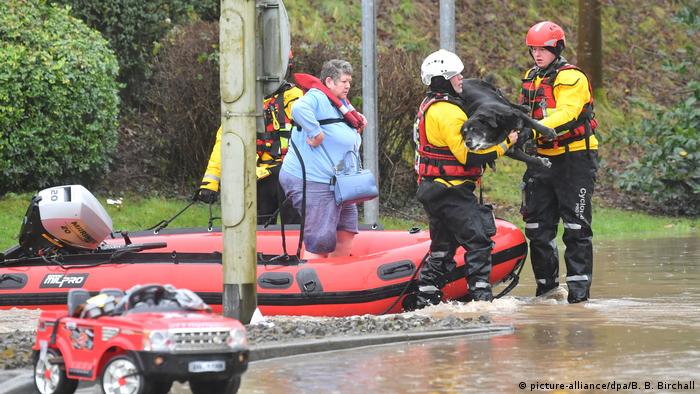 Rescuers carry dog in heavy flooding