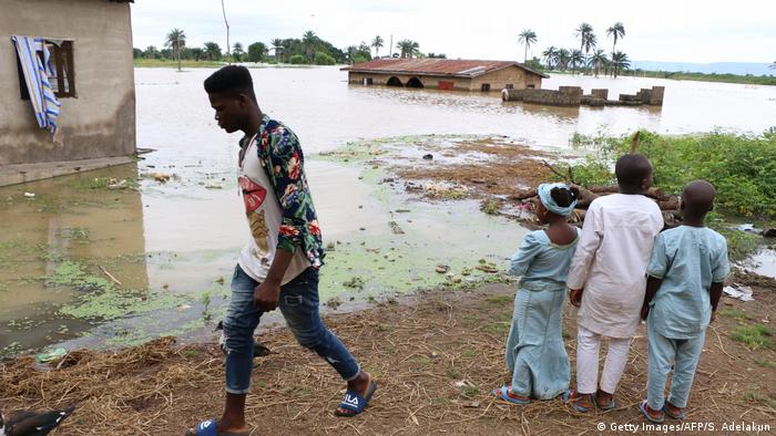Nigeria floods with people standing by the river
