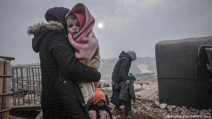 Syrian families are seen at a camp in Turmanin near the Turkish border on a cold winter day in Idlib, Syria, on February 14, 2020
