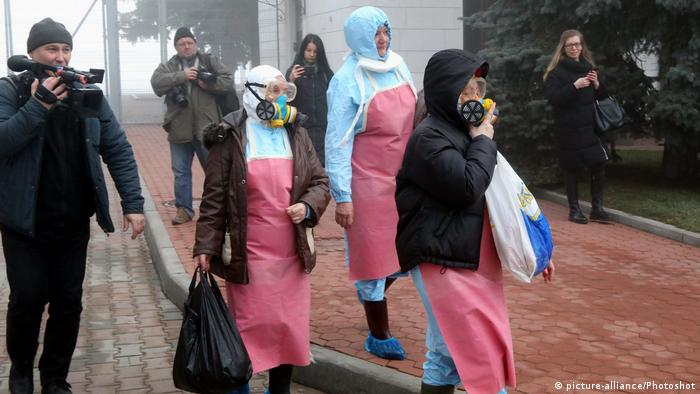 People walking with gas masks in the city of Novi Sanzhary 