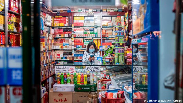 China Peking | Ladenbesitzer mit Gesichtsmaske (Getty Images/AFP/N. Asfouri)