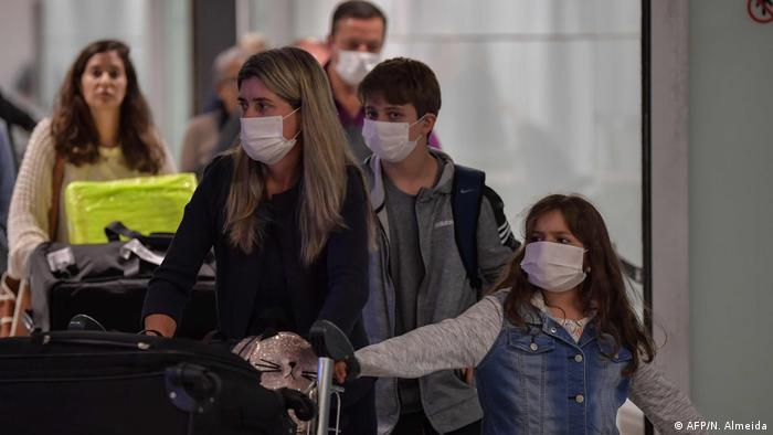 Pessoas com máscaras no aeroporto de Guarulhos