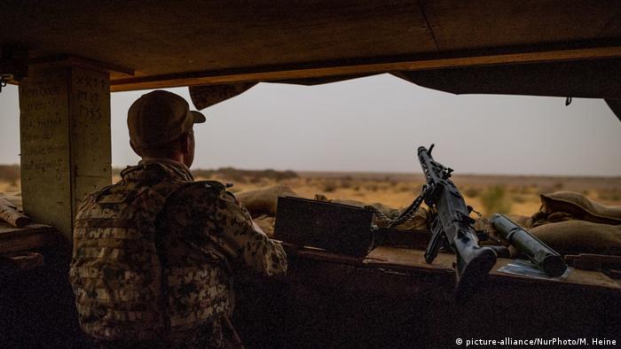 A member of the German Bundeswehr secures an area in Mali