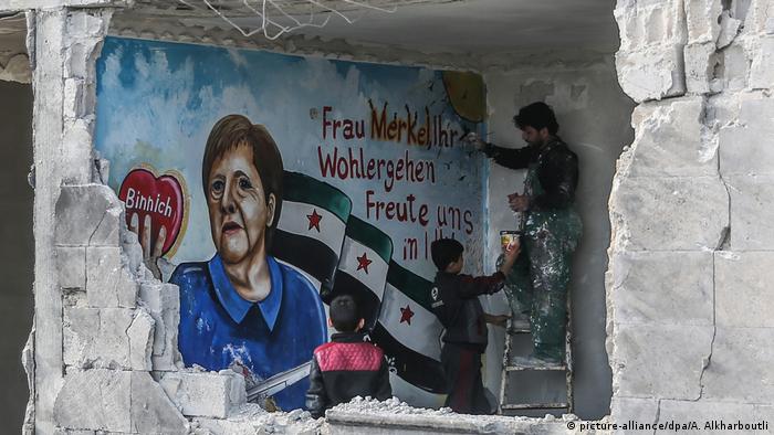 Em ruínas de Binnish, na Síria, pintor homenageou Merkel em março