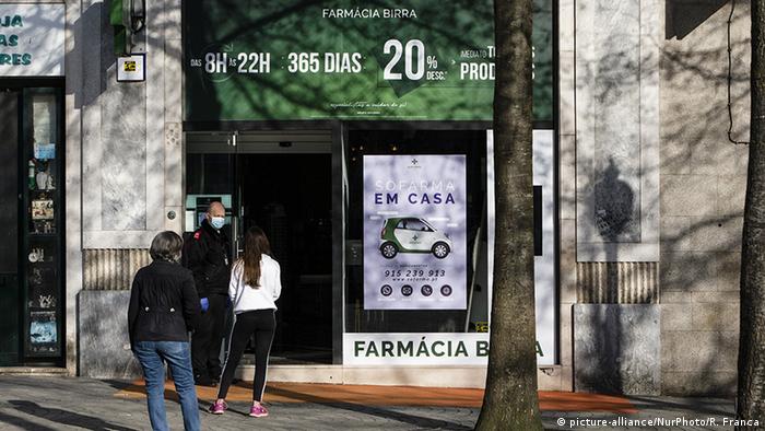 Pessoas esperam em fila de farmácia no Porto, em Portugal
