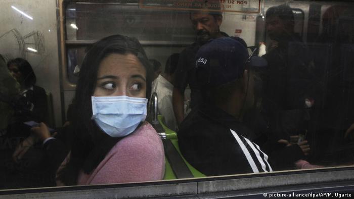 A woman wearing a mask rides in the Mexico City's subway