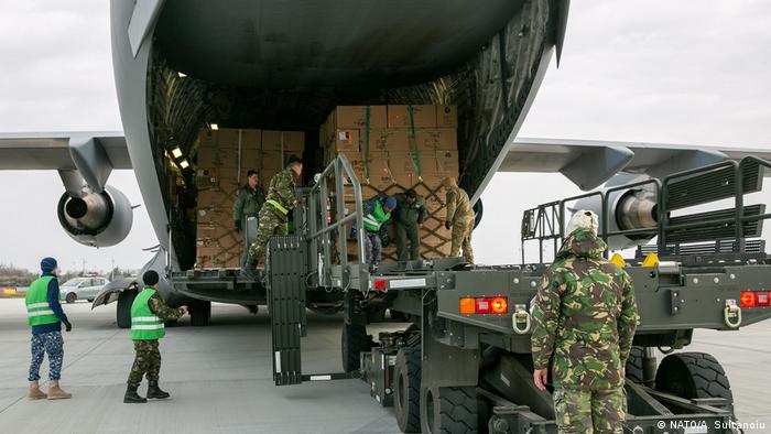 The Romanian military unloads emergency assistance it purchased from South Korea and shipped with C-130s it shares in a NATO program. 