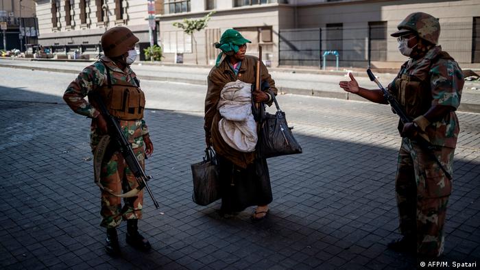South African police speak with a homeless woman during the coronavirus lockdown (AFP/M. Spatari)